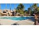 Community pool surrounded by a secure fence and lush palm trees at 1150 N Buffalo Dr # 1015, Las Vegas, NV 89128