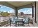 Balcony with a wrought iron railing and a table with chairs overlooking palm trees and neighborhood at 11820 Calle De Sol Dr, Las Vegas, NV 89138