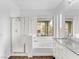 Bright bathroom featuring a walk-in shower, soaking tub, and granite countertop vanity with natural light at 11820 Calle De Sol Dr, Las Vegas, NV 89138