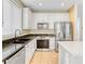 Modern kitchen features white cabinets, stainless appliances, and a sleek black countertop at 11820 Calle De Sol Dr, Las Vegas, NV 89138