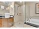 Bright bathroom featuring a soaking tub with black countertop and glass-enclosed shower at 145 E Harmon Ave # 2917, Las Vegas, NV 89109