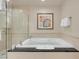 Bright bathroom featuring a soaking tub with black countertop and glass-enclosed shower at 145 E Harmon Ave # 2917, Las Vegas, NV 89109