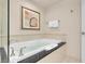 Bright bathroom featuring a soaking tub with black countertop and glass-enclosed shower at 145 E Harmon Ave # 2917, Las Vegas, NV 89109