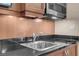 Close up of the kitchenette with stainless steel sink, appliances and dark counter tops at 145 E Harmon Ave # 2917, Las Vegas, NV 89109