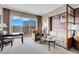 Open living area features couch, table, desk, and large windows with a view of the city at 145 E Harmon Ave # 2917, Las Vegas, NV 89109