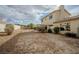 Expansive backyard featuring a desert landscape, a stucco wall, a covered patio, and mature shrubbery at 172 Cloudcrest Dr, Henderson, NV 89015