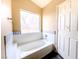 Bright bathroom features a soaking tub with a window view and white tiled walls at 172 Cloudcrest Dr, Henderson, NV 89015