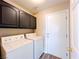 Functional laundry room with dark upper cabinets and included washer and dryer at 172 Cloudcrest Dr, Henderson, NV 89015