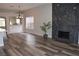 Spacious living area with dark stone fireplace, lots of natural light, and access to the kitchen at 1908 Quail Point Ct, Las Vegas, NV 89117