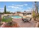 Expansive backyard with a refreshing pool, trampoline, brick patio with firepit, perfect for entertaining and enjoying outdoor living at 212 N Torrey Pines Dr, Las Vegas, NV 89107