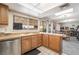 Kitchen with stainless steel dishwasher and wooden cabinets with connecting view of living area at 212 N Torrey Pines Dr, Las Vegas, NV 89107