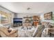 Cozy living room featuring a stone fireplace, comfortable seating, and a large window at 212 N Torrey Pines Dr, Las Vegas, NV 89107