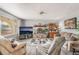 Cozy living room featuring a stone fireplace, comfortable seating, and a large window at 212 N Torrey Pines Dr, Las Vegas, NV 89107