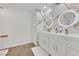 Bathroom boasts marble tile accent wall with double sink vanity and backlit mirrors at 2221 Mohawk St, Las Vegas, NV 89146