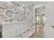 Bathroom boasts marble tile accent wall with double sink vanity and backlit mirrors at 2221 Mohawk St, Las Vegas, NV 89146