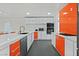 Modern kitchen featuring sleek white cabinets, vibrant orange accents, and stainless steel appliances at 2221 Mohawk St, Las Vegas, NV 89146