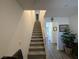Carpeted staircase with white railing ascends to the upper level, complemented by nearby wall decor at 2775 Atomic Tangerine Way # 4, Las Vegas, NV 89183
