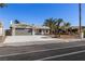 Charming single-story home featuring a two-car garage, palm trees, and a well-manicured front yard at 3916 S Torrey Pines Dr, Las Vegas, NV 89103