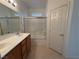Bathroom with double sinks, wood cabinets and bath with showerhead and sliding glass door at 3936 Pepper Thorn Ave # 102, North Las Vegas, NV 89081