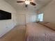 Bedroom with a ceiling fan, windows and TV, and double closets with white doors at 3936 Pepper Thorn Ave # 102, North Las Vegas, NV 89081