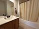 Cozy bathroom featuring a vanity with sink and a shower-tub combination with a neutral-colored curtain at 3936 Pepper Thorn Ave # 102, North Las Vegas, NV 89081