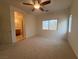 Bright bedroom with carpet, ceiling fan and a view to the on-suite bathroom at 3936 Pepper Thorn Ave # 3, North Las Vegas, NV 89081