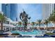 Stunning pool area with a massive statue surrounded by lounge seating and palm trees at 4381 W Flamingo Rd # 1510, Las Vegas, NV 89103