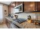Close up on kitchen counter featuring granite countertops and stainless steel microwave at 4606 Engage St, North Las Vegas, NV 89031