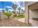 Landscaped backyard with a patio, gravel area, lawn, and palm trees, creating a serene outdoor space at 4679 El Camino Cabos Dr, Las Vegas, NV 89147