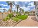Lush backyard with a manicured lawn, garden beds, walkway, and ample space for outdoor enjoyment at 4679 El Camino Cabos Dr, Las Vegas, NV 89147