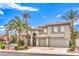 Beautiful two-story home boasts a three-car garage and lush landscaping with desert foliage and palm trees at 4679 El Camino Cabos Dr, Las Vegas, NV 89147
