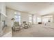 Open living area features large windows, and neutral carpet, and fireplace at 4679 El Camino Cabos Dr, Las Vegas, NV 89147