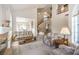 Open-concept living room with vaulted ceilings, fireplace, and staircase to second floor create a warm atmosphere at 4679 El Camino Cabos Dr, Las Vegas, NV 89147