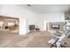 Cozy living room with fireplace, neutral carpet and doorway into dining area at 4679 El Camino Cabos Dr, Las Vegas, NV 89147