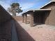 Enclosed backyard featuring a covered patio, block wall fencing, and decorative rock landscaping at 4843 Lana Dr, Las Vegas, NV 89121