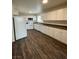 Spacious kitchen featuring white appliances, ample cabinetry, and dark wood-look flooring at 4843 Lana Dr, Las Vegas, NV 89121