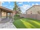 This manicured backyard is landscaped with lush artificial turf and a covered patio for relaxation and entertaining at 5 Rampart Ct, Henderson, NV 89074