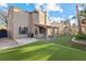A spacious backyard features a covered patio, artificial grass, and a playhouse, perfect for outdoor enjoyment at 5 Rampart Ct, Henderson, NV 89074