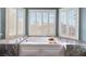 Bathroom featuring a soaking tub with shutters overlooking a scenic view at 5 Rampart Ct, Henderson, NV 89074