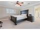 Bedroom with a dark wood bed frame, nightstand, ceiling fan, and plantation shutters at 5 Rampart Ct, Henderson, NV 89074