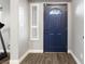 Inviting entryway featuring a striking blue front door and stylish wood-look flooring at 5 Rampart Ct, Henderson, NV 89074