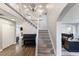 Open foyer with staircase, light gray walls, and wood-look floors, complemented by a piano at 5 Rampart Ct, Henderson, NV 89074