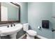 Half bath features modern toilet, stylish sink, and a dark wood framed mirror at 5 Rampart Ct, Henderson, NV 89074