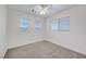 A standard bedroom with carpet and three windows at 5044 Whistling Acres Ave, Las Vegas, NV 89131