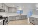 Updated kitchen with gray cabinetry, stainless appliances, and light countertops at 5044 Whistling Acres Ave, Las Vegas, NV 89131