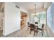 Dining area next to open kitchen features wood-style floors, window, and modern chandelier at 51 E Agate Ave # 205, Las Vegas, NV 89123