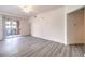 Bright, open-concept living room with grey wood flooring, ceiling fan and slider to balcony at 51 E Agate Ave # 205, Las Vegas, NV 89123