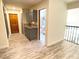 Hallway features wood floors, cabinets, decor, and views to an updated bathroom and wrought iron railing at 5381 Waving Sage Dr, Las Vegas, NV 89149