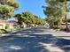 This street view features mature trees lining the road and houses in the background at 5381 Waving Sage Dr, Las Vegas, NV 89149