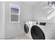 Well-lit laundry room with modern washer and dryer, plus convenient shelving at 5398 Pico Viejo St, Las Vegas, NV 89166